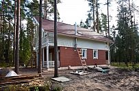 Строительство каркасного коттеджа 220 кв м аля шале с широкими кровельными свесами и остекленной верандой в комбинированной фасадной отделке красным лицевым кирпичом и белым имитатором бруса в п Вырица - мини - 2