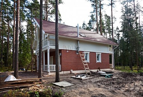 Строительство каркасного коттеджа 220 кв м аля шале с широкими кровельными свесами и остекленной верандой в комбинированной фасадной отделке красным лицевым кирпичом и белым имитатором бруса в п Вырица - 2