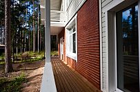 Строительство каркасного коттеджа 220 кв м аля шале с широкими кровельными свесами и остекленной верандой в комбинированной фасадной отделке красным лицевым кирпичом и белым имитатором бруса в п Вырица - мини - 8