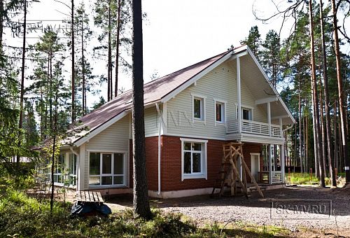 Строительство каркасного коттеджа 220 кв м аля шале с широкими кровельными свесами и остекленной верандой в комбинированной фасадной отделке красным лицевым кирпичом и белым имитатором бруса в п Вырица - 12