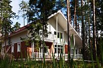 Строительство каркасного коттеджа 220 кв м аля шале с широкими кровельными свесами и остекленной верандой в комбинированной фасадной отделке красным лицевым кирпичом и белым имитатором бруса в п Вырица - мини - 1