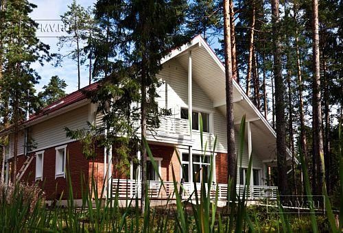 Строительство каркасного коттеджа 220 кв м аля шале с широкими кровельными свесами и остекленной верандой в комбинированной фасадной отделке красным лицевым кирпичом и белым имитатором бруса в п Вырица - 1