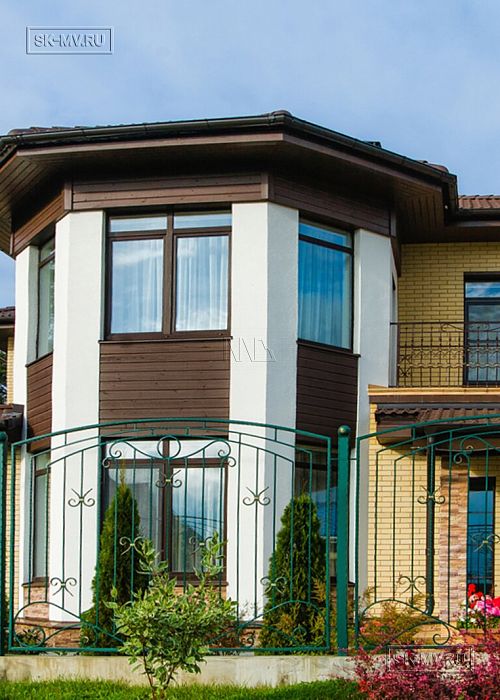 Построенный газобетонный дом в классическом стиле с эркером, балконом, навесом для автомобиля, остекленной верандой и комбинированной фасадной отделкой в кп Сосновое