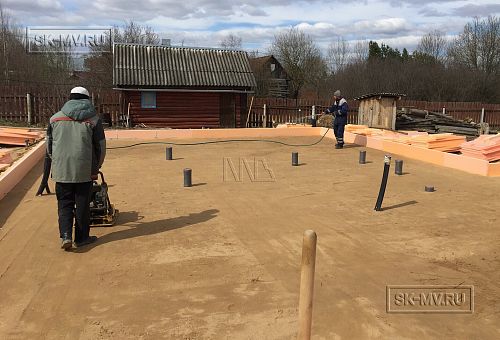 Проливка водой и уплотнение песчаного основания фундамента