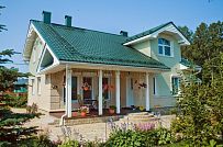 Построенный каркасный дом в п Озерное чуть более 170 кв.м с комбинированной отделкой бежевым кирпичом и зеленой отделочной доской, с террасой, навесом на два автомобиля и четырьмя спальнями - мини - 5