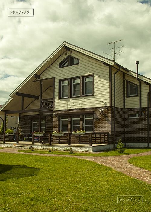 Строительство двухэтажного каркасного коттеджа шале около 300 кв м с комбинированной отделкой коричневым кирпичом и деревом в п Володарский