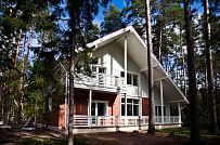 Строительство каркасного коттеджа 220 кв м аля шале с широкими кровельными свесами и остекленной верандой в комбинированной фасадной отделке красным лицевым кирпичом и белым имитатором бруса в п Вырица - мини - 7