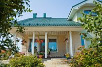 Построенный каркасный дом в п Озерное чуть более 170 кв.м с комбинированной отделкой бежевым кирпичом и зеленой отделочной доской, с террасой, навесом на два автомобиля и четырьмя спальнями - мини - 2