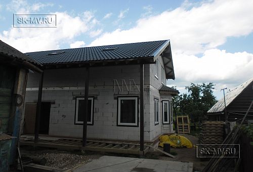 Окончание работ по монтажу кровельного покрытия из металлочерепицы с мансардными окнами Velux. Установлены в проектное положение опорные стойки из клееного бруса и лаги пола из импрегнированной доски навеса крыльца при входе в дом.