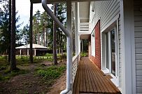 Строительство каркасного коттеджа 220 кв м аля шале с широкими кровельными свесами и остекленной верандой в комбинированной фасадной отделке красным лицевым кирпичом и белым имитатором бруса в п Вырица - мини - 11