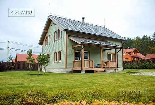Построенный в п Борисово небольшой двухэтажный каркасный дом 147 кв.м с фасадом из светло зеленой вагонки, сауной, навесом для авто и четырьмя спальнями - 1
