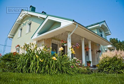 Построенный каркасный дом в п Озерное чуть более 170 кв.м с комбинированной отделкой бежевым кирпичом и зеленой отделочной доской, с террасой, навесом на два автомобиля и четырьмя спальнями - 1