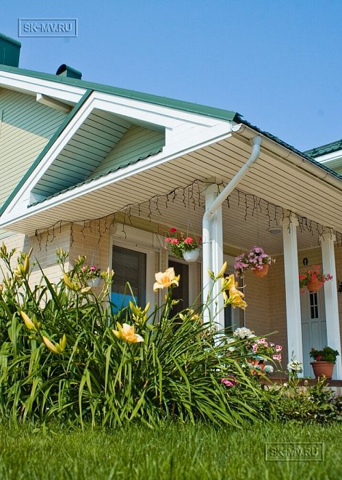 Построенный каркасный дом в п Озерное чуть более 170 кв.м с комбинированной отделкой бежевым кирпичом и зеленой отделочной доской, с террасой, навесом на два автомобиля и четырьмя спальнями